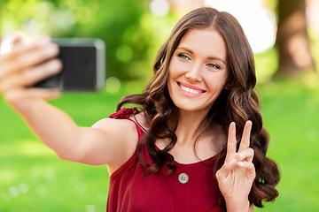 Image showing happy woman with smartphone taking selfie at park