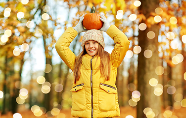 Image showing happy girl with pumpkin at autumn park