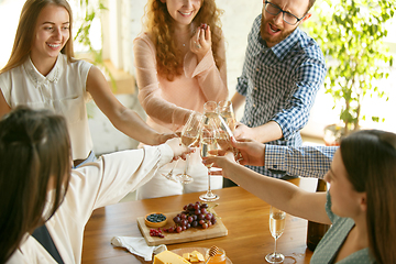 Image showing People clinking glasses with wine or champagne. Happy cheerful friends celebrate holidays, meeting. Close up shot of smiling friends, lifestyle