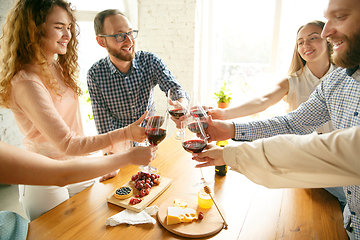 Image showing People clinking glasses with wine or champagne. Happy cheerful friends celebrate holidays, meeting. Close up shot of smiling friends, lifestyle