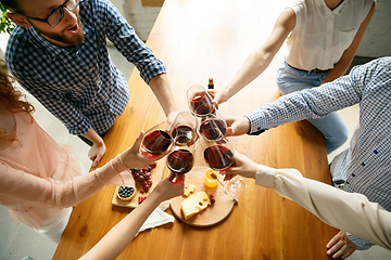 Image showing People clinking glasses with wine or champagne. Happy cheerful friends celebrate holidays, meeting. Close up shot of smiling friends, lifestyle