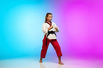 Image showing Karate, taekwondo girl with black belt isolated on gradient background in neon light