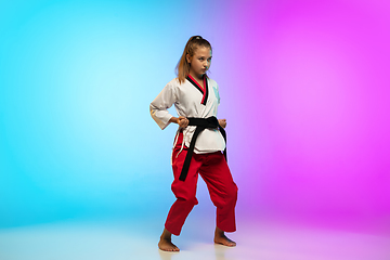 Image showing Karate, taekwondo girl with black belt isolated on gradient background in neon light