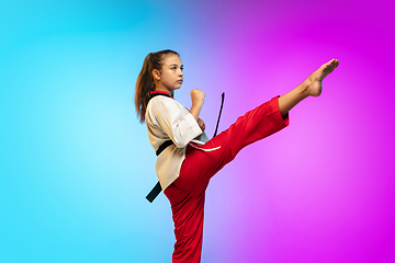 Image showing Karate, taekwondo girl with black belt isolated on gradient background in neon light