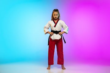 Image showing Karate, taekwondo girl with black belt isolated on gradient background in neon light