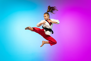 Image showing Karate, taekwondo girl with black belt isolated on gradient background in neon light