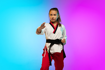 Image showing Karate, taekwondo girl with black belt isolated on gradient background in neon light