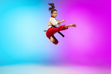 Image showing Karate, taekwondo girl with black belt isolated on gradient background in neon light