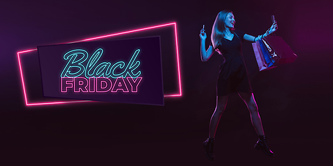 Image showing Portrait of young woman in neon light on dark backgound. The human emotions, black friday, cyber monday, purchases, sales, finance concept. Neoned lettering.