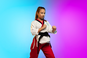 Image showing Karate, taekwondo girl with black belt isolated on gradient background in neon light