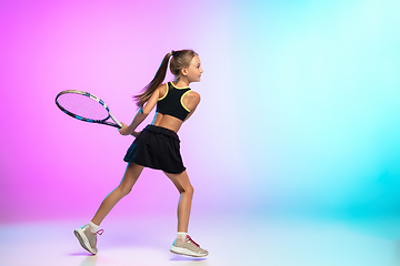 Image showing Little tennis girl in black sportwear isolated on gradient background in neon light