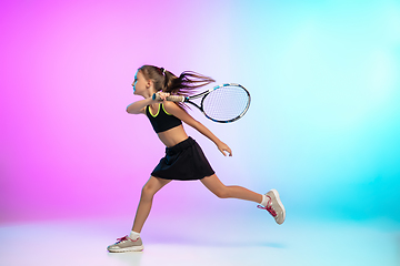 Image showing Little tennis girl in black sportwear isolated on gradient background in neon light