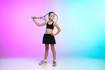 Image showing Little tennis girl in black sportwear isolated on gradient background in neon light