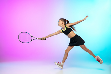 Image showing Little tennis girl in black sportwear isolated on gradient background in neon light