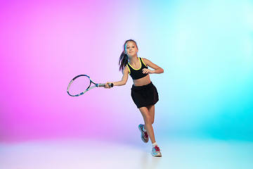 Image showing Little tennis girl in black sportwear isolated on gradient background in neon light