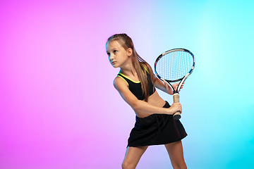 Image showing Little tennis girl in black sportwear isolated on gradient background in neon light