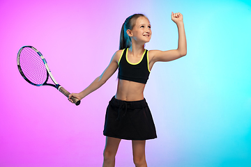 Image showing Little tennis girl in black sportwear isolated on gradient background in neon light