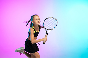 Image showing Little tennis girl in black sportwear isolated on gradient background in neon light