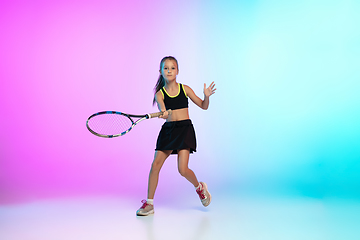 Image showing Little tennis girl in black sportwear isolated on gradient background in neon light