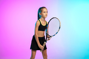 Image showing Little tennis girl in black sportwear isolated on gradient background in neon light