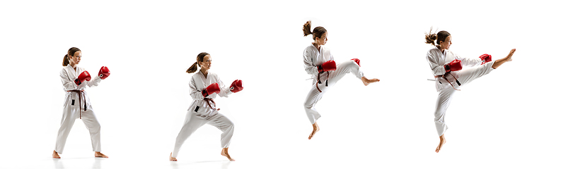 Image showing Confident junior in kimono practicing taekwondo combat, martial arts