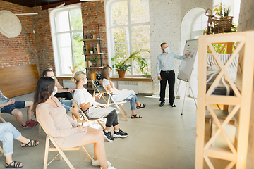 Image showing Male speaker giving presentation in hall at university workshop. Audience or conference hall