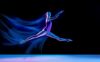 Image showing Young and graceful ballet dancer isolated on black studio background in neon mixed light