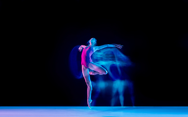 Image showing Young and graceful ballet dancer isolated on black studio background in neon mixed light