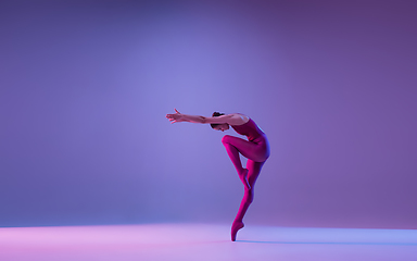 Image showing Young and graceful ballet dancer isolated on purple studio background in neon light