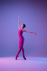 Image showing Young and graceful ballet dancer isolated on purple studio background in neon light