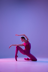 Image showing Young and graceful ballet dancer isolated on purple studio background in neon light