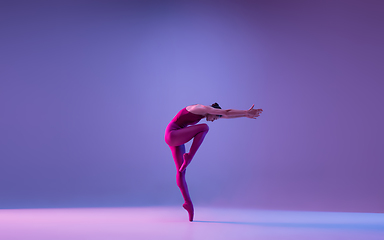 Image showing Young and graceful ballet dancer isolated on purple studio background in neon light