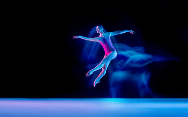 Image showing Young and graceful ballet dancer isolated on black studio background in neon mixed light