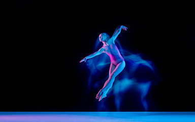 Image showing Young and graceful ballet dancer isolated on black studio background in neon mixed light