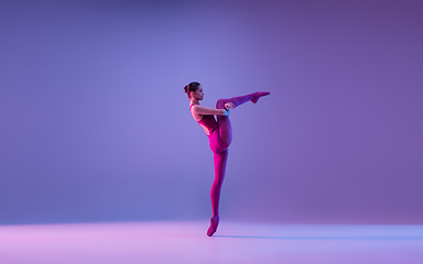 Image showing Young and graceful ballet dancer isolated on purple studio background in neon light