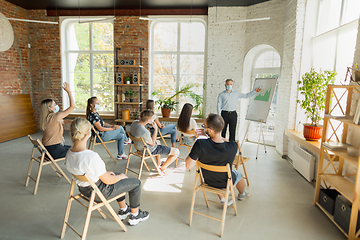 Image showing Male speaker giving presentation in hall at university workshop. Audience or conference hall