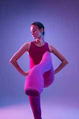 Image showing Young and graceful ballet dancer isolated on purple studio background in neon light