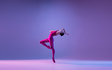 Image showing Young and graceful ballet dancer isolated on purple studio background in neon light