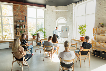 Image showing Male speaker giving presentation in hall at university workshop. Audience or conference hall