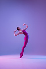 Image showing Young and graceful ballet dancer isolated on purple studio background in neon light