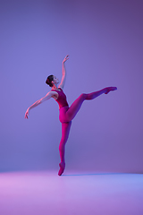 Image showing Young and graceful ballet dancer isolated on purple studio background in neon light