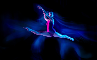 Image showing Young and graceful ballet dancer isolated on black studio background in neon mixed light