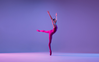 Image showing Young and graceful ballet dancer isolated on purple studio background in neon light