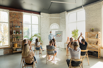 Image showing Male speaker giving presentation in hall at university workshop. Audience or conference hall