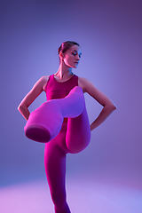 Image showing Young and graceful ballet dancer isolated on purple studio background in neon light