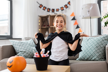 Image showing girl in halloween costume with bat cape at home