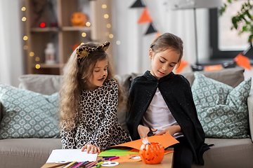 Image showing girls in halloween costumes doing crafts at home