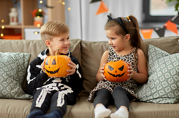 Image showing kids in halloween costumes with pumpkins at home