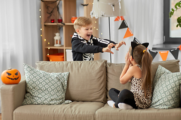 Image showing kids in halloween costumes playing at home