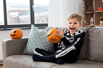 Image showing boy in halloween costume with pumpkin at home